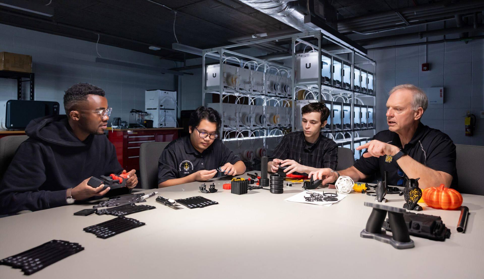 Students and a professor at 正规博彩十大网站排名's SPCEET collaborate on a project involving 3D-printed components in a technology lab.