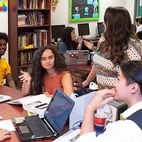 gloval village students talking at a table